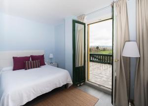 卡萨拉雷纳欧雅山谷酒店的一间卧室设有一张床,并有通往阳台的门
