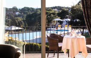 雅弗郎其Hotel BlauMar Llafranc的阳台配有桌椅,享有泳池美景