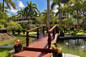 圣斐利-银港多拉达海岸伊波罗之星酒店&度假村的一座位于度假村池塘上的木桥