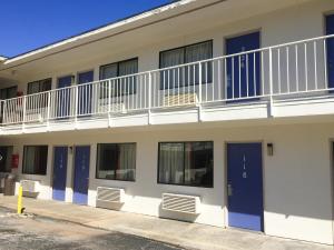 彭萨科拉Motel 6 - Pensacola West的公寓大楼设有阳台和蓝色门