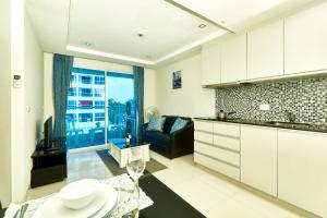 南芭堤雅Novana Residence by Tech的厨房以及带沙发和桌子的客厅。