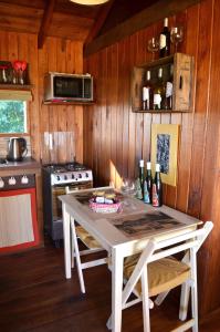 卡梅隆EntreViñas的厨房配有带2把椅子的桌子和炉灶。