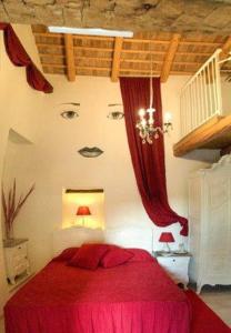 Borgo Grotta GiganteBed & Breakfast Barbara的卧室配有一张红色的床,墙上有一张脸