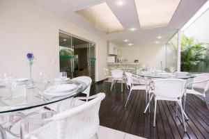 巴西利亚维罗那哈普拉斯长住公寓式酒店的一间设有白色椅子和桌子的用餐室