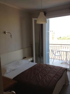 卡尔热斯Hotel Cyrnos的一间卧室设有一张床,享有阳台的景色