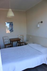 卡尔热斯Hotel Cyrnos的卧室配有白色的床和桌椅