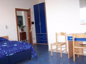 伊斯基亚阿丽博格鲁康达苏鲁玛尔酒店的卧室配有一张床和一张桌子及椅子