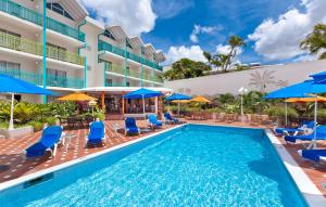 布里奇敦蓝色地平线酒店的一座带蓝色椅子和遮阳伞的酒店游泳池