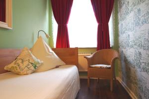 不莱梅布莱梅伽斯特豪斯酒店的卧室配有床、椅子和窗户。