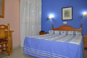 卡塞雷斯奥克萨瑞斯旅馆的一间卧室配有一张蓝色墙壁的床