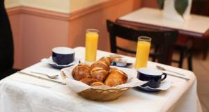 巴黎凯尔特人酒店的一张桌子,上面放着一篮羊角面包和橙汁