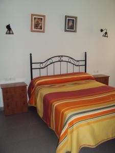 科迪加纳埃尔塞顿酒店的一间卧室配有一张带彩色条纹毯子的床