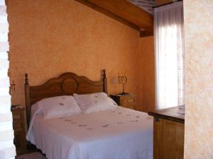 Cedillo de la TorreHotel Rural El Museo的一间卧室配有一张带白色床单的床和一扇窗户。
