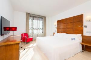萨拉戈萨Hotel Zentral Ave的卧室配有一张白色大床和红色椅子