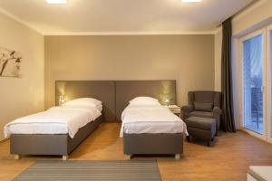 新伊钦Apartmány Abacie的酒店客房,配有两张床和椅子