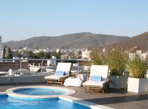 萨尔塔艾尔代萨尔塔酒店的一个带两把椅子的庭院和一个屋顶游泳池