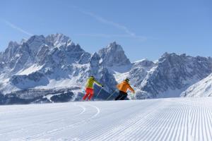 圣坎迪朵Appartements Schäfer的两个人在雪覆盖的山里滑雪