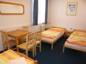 布拉格哈萨酒店的一间设有两张床和一张桌子及椅子的房间