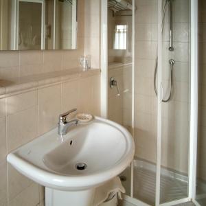 PegognagaHotel Ristorante Novecento的白色的浴室设有水槽和淋浴。