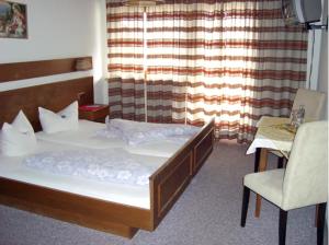 维辛Hotel Sonnhof的卧室配有床、椅子和窗户。