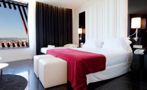 略夫雷加特河畔奥斯皮塔莱特费拉港四星超级酒店的卧室配有一张大白色床和红色毯子