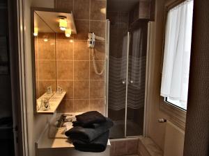 潘波勒Hotel Restaurant de la Marne的浴室配有盥洗盆、淋浴和毛巾