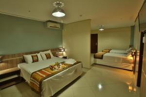 库亚巴派古兹帕拉斯酒店的酒店客房设有两张床和一张桌子。