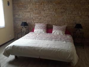 Villars格朗斯住宿加早餐旅馆的一间卧室设有一张带砖墙的大床