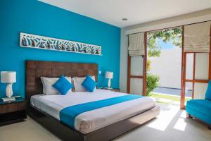 勒吉安萨马纳别墅 的一间卧室设有一张大床和蓝色的墙壁