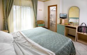 米兰马瑞提那Hotel Boccaccio-free parking-的一间带一张床和一张书桌的卧室以及一间浴室。