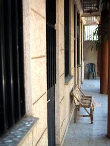 巴赫达尔Manuhie Backpackers Lodge的坐在建筑物边的长凳
