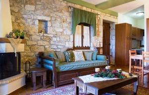 VarvítsaMeterizi Guesthouse的客厅设有蓝色的沙发和石墙