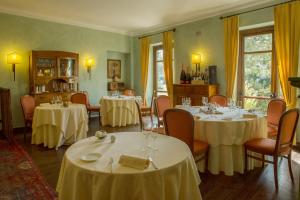 圣弗朗西斯科尔坎姆弗诺罗浪漫酒店的用餐室配有桌椅和白色桌布