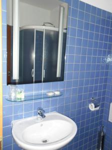 塞尼察Hotel Arli的蓝色瓷砖浴室设有水槽和镜子