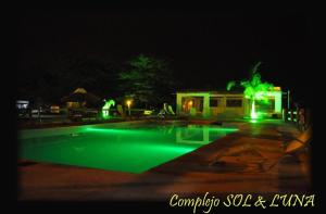 GualeguaychúComplejo Sol y Luna的夜晚带绿灯的游泳池