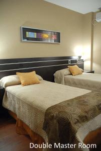 圣米格尔·德·图库玛弗朗西亚酒店的酒店客房设有两张床和窗户。