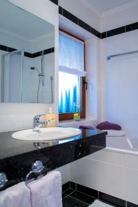 巴特柯尼希祖尔博斯特兰德酒店的一间带水槽和淋浴的浴室以及窗户。