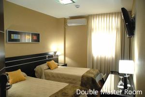 圣米格尔·德·图库玛弗朗西亚酒店的酒店客房设有两张床和窗户。