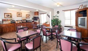 史密斯堡Rest Inn Fort Smith的一间带桌椅的用餐室和一间厨房