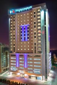 麦纳麦巴林假日酒店的一座大型建筑,上面有蓝色的灯光