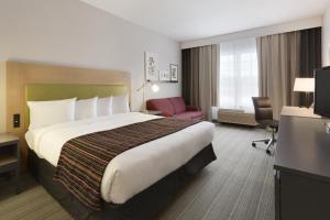 Schofield斯科菲尔德江山旅馆及套房的酒店客房带一张大床和一把椅子