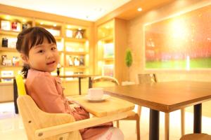 首尔东大门阿酷酒店的坐在桌子上坐在椅子上的一个小女孩