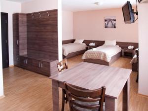 季米特洛夫格勒Motel Maritsa的一间带餐桌的客厅和一间卧室