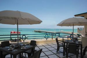 萨利纳斯蓝湾酒店的一个带桌子和遮阳伞的庭院和大海
