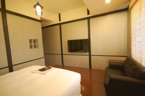 恒春古城花野井的客房设有床、沙发和电视。