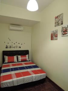 马六甲匹洛胡斯旅馆的一间卧室配有带条纹毯子的床