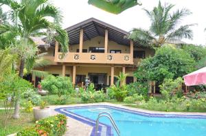 马拉维拉所罗门海滩酒店 的一座带游泳池的度假村,位于一座建筑前