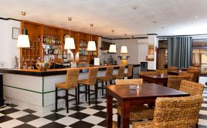 埃尔阿雷纳尔迪拉马尔旅馆的餐厅内的酒吧配有桌椅