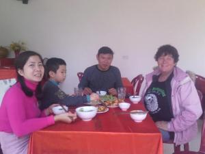 Nho QuanCuc Phuong Bungalow的一群坐在餐桌上吃食物的人