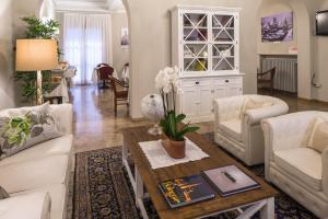 博洛尼亚阿卡迪米亚酒店的客厅配有白色家具和桌子